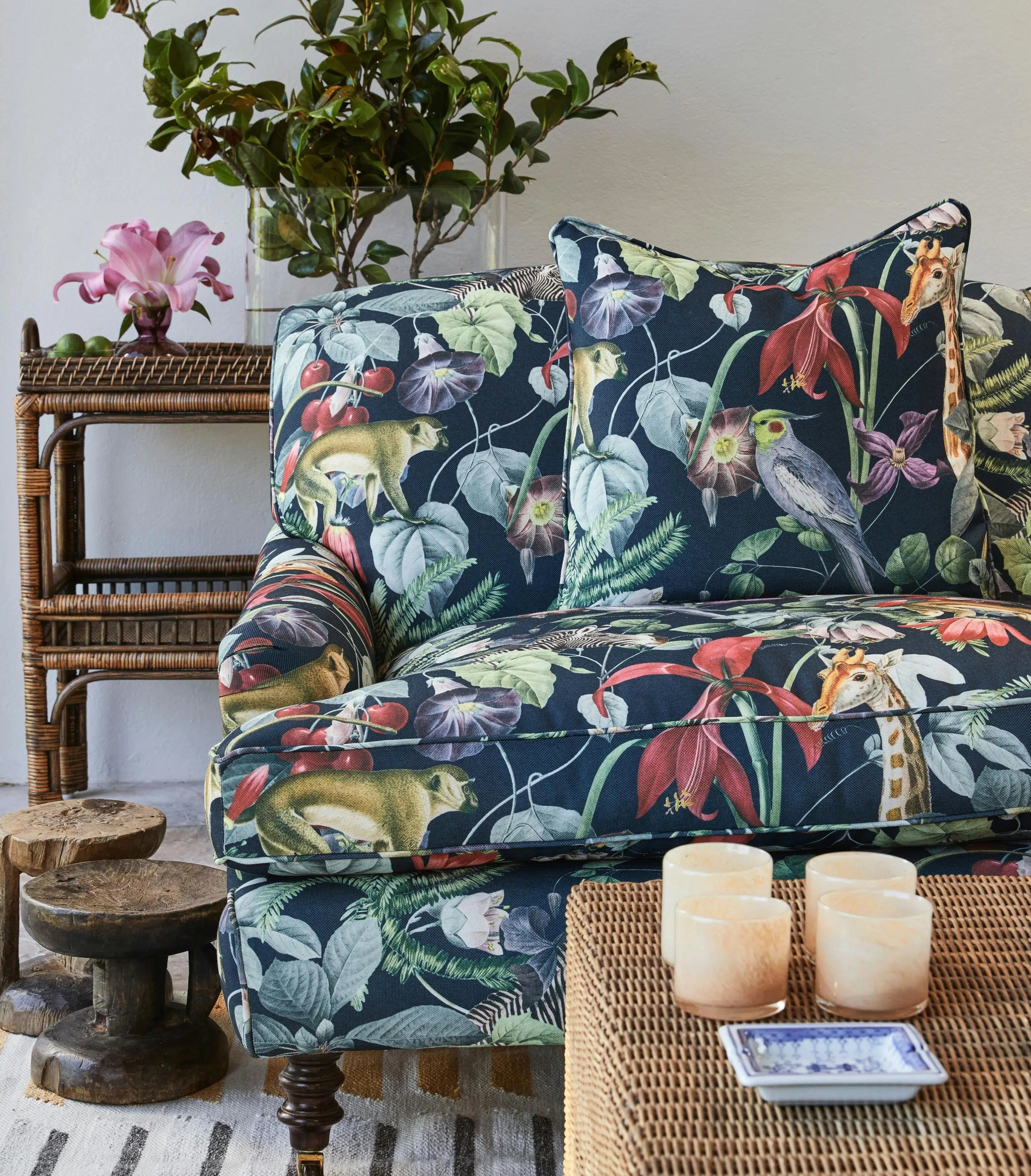 An armchair with tropical upholstery with a weaved coffee table just in front.
